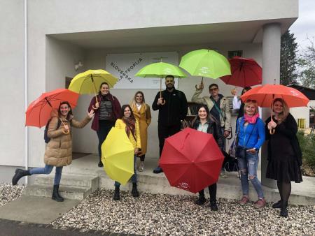 Skupinska fotografija projektnih partnerjev s pisanimi dežniki ob obisku Slovenske filantropije